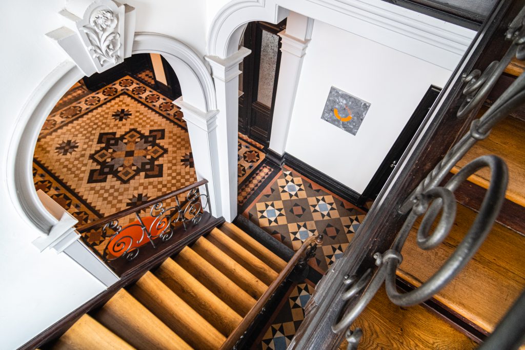 Das Bild zeigt das Treppenhaus der Firma Thees und Partner mit schönen Mosaikfliesen