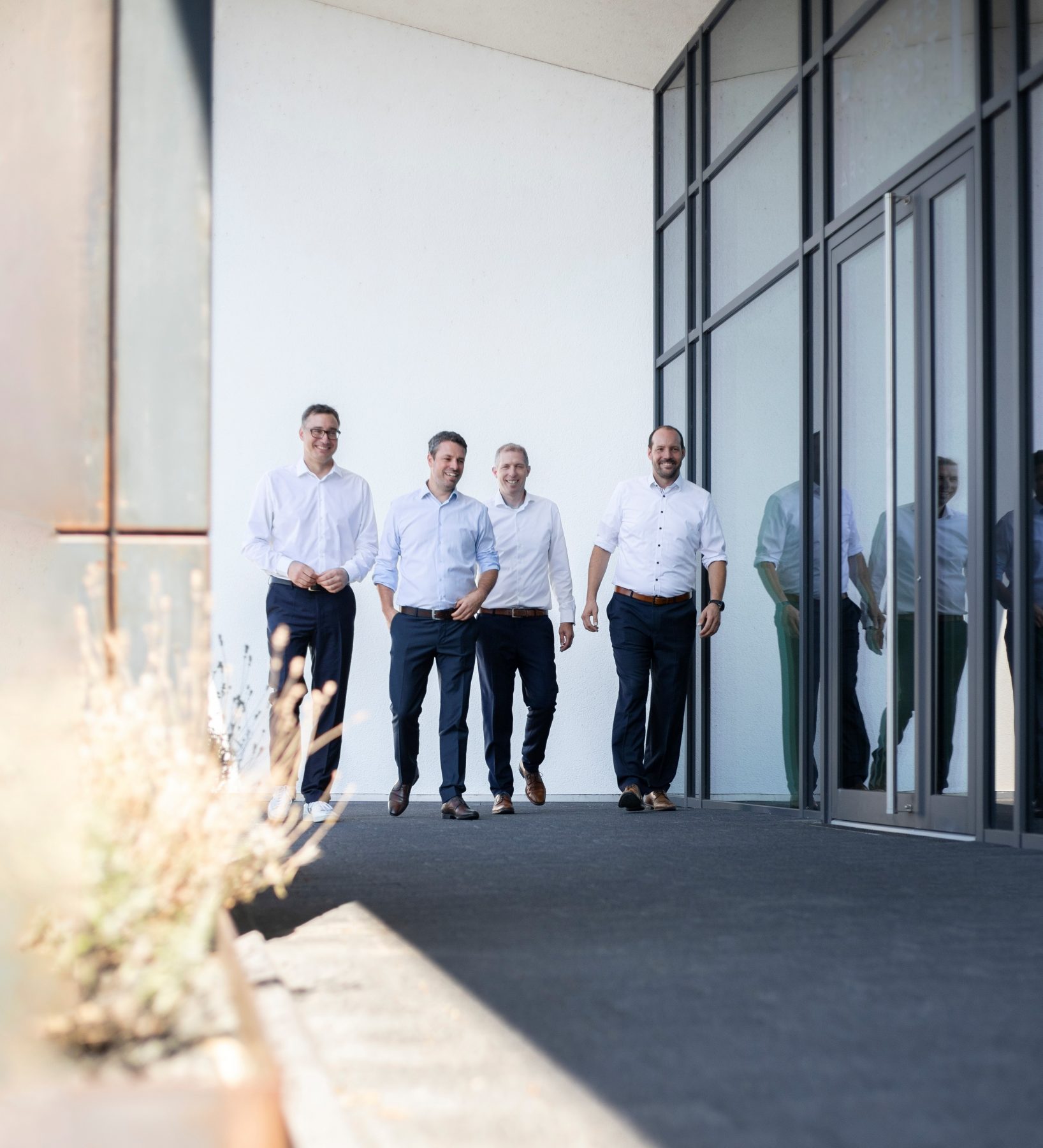 Das Bild zeigt den Inhaber und die Partner der Firma Thees und Partner bei einem Spaziergang über das Firmengelände