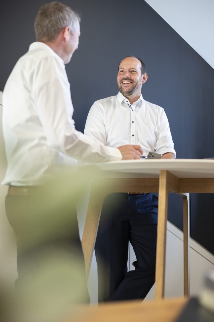 Das Bild zeigt zwei freundliche Partner der Firma Thees und Partner im Gespräch