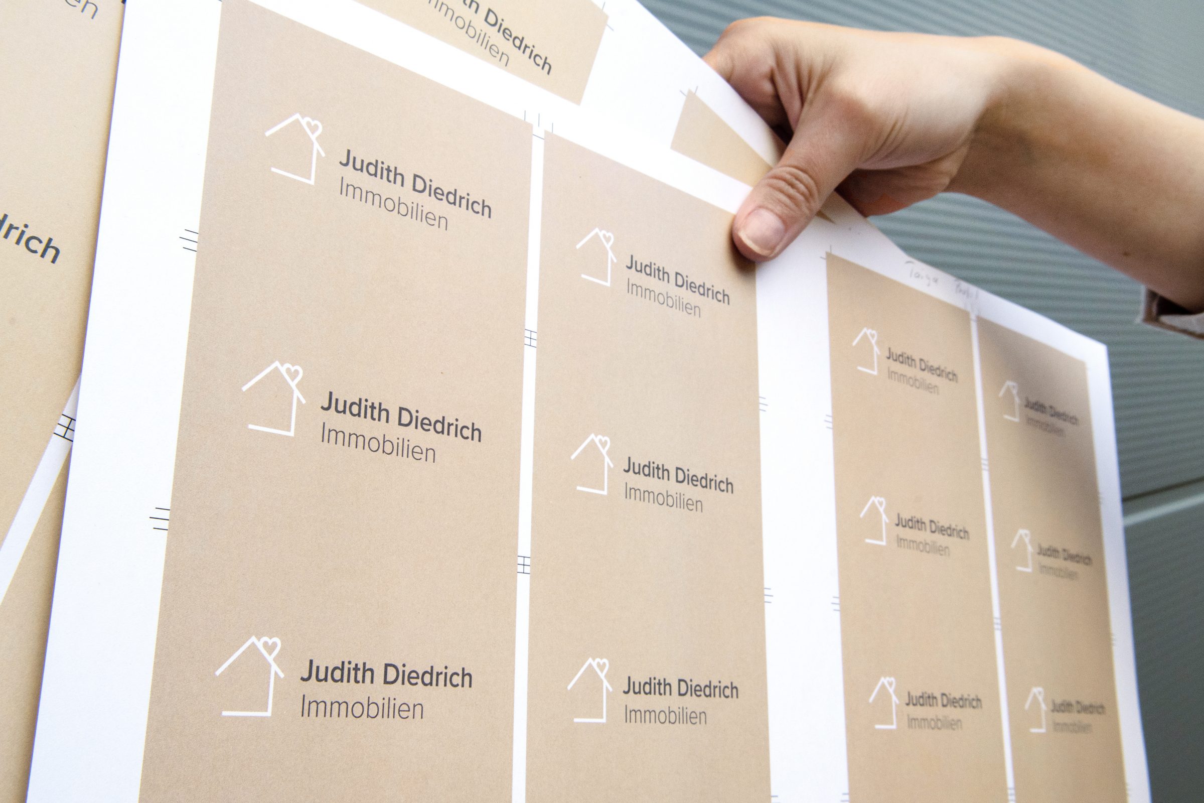 Das Bild zeigt ein Foto von Druckbögen der Visitenkarten für Judith Diedrich Immobilien